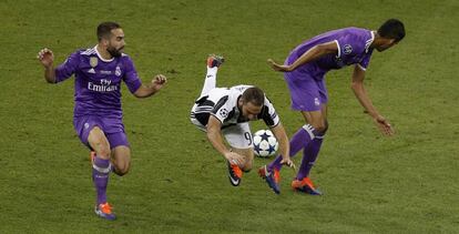 Higua&iacute;n cae al suelo entre Varane y Carvajal.