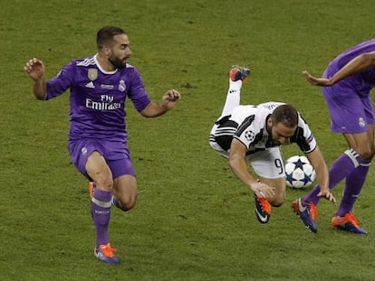 Higua&iacute;n cae al suelo entre Varane y Carvajal.