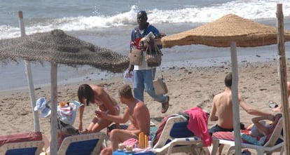 Un vendedor, en una zona de hamacas de la costa malagueña.