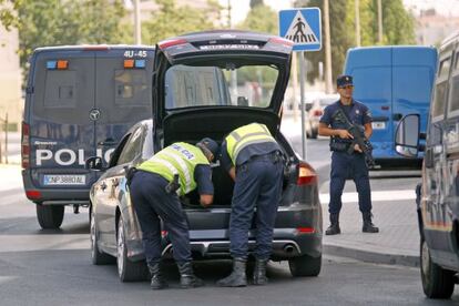 Police search a vehicle in the Tres Mil Viviendas area of Seville Friday. 