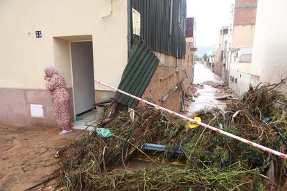 Una mujer en la puerta de su vivienda en Alcanar (Tarragona), tras la tromba de agua, este miércoles.