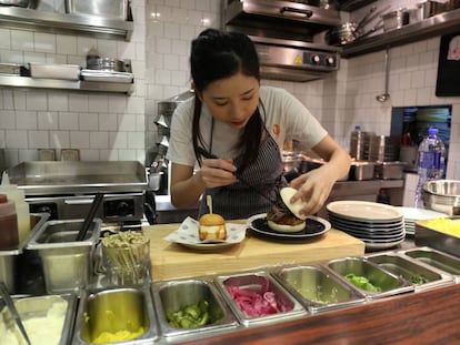 Personal del restaurante Little Bao preparando dos de las especialidades.