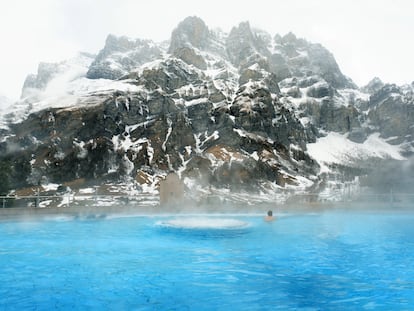 Piscina exterior del balneario Walliser Alpentherme Burgerbad & Spa Leukerbad, en Suiza, con la montaña Gemmi como telon de fondo.