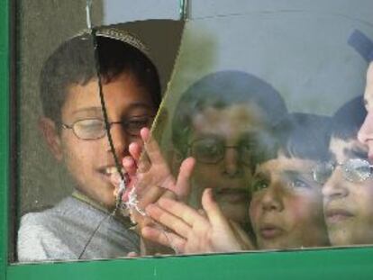 Unos niños israelíes, ante la ventana rota en su escuela por uno de los obuses palestinos.