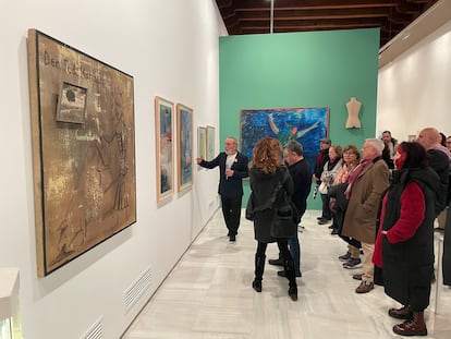 El pintor Pablo Sycet explica a visitantes la exposición 'Fin de siglo', con obras de su colección, en el Espacio Santa Clara, en diciembre.