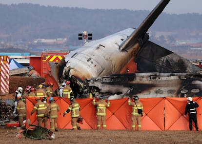 Bomberos y personal de rescate trabajan entre los restos del avin siniestrado este domingo en el aeropuerto de Muan (Corea del Sur).