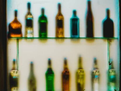 Varias botellas de alcohol en los estantes de un bar.