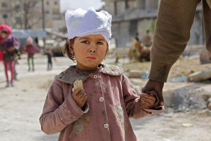 Una niña siria herida pasea de la mano de su padre en Kfar Batna, Guta Oriental (Siria). 