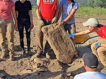 Un arqueólogo señala la estela con diadema hallada en el yacimiento de Las Capellanías (Huelva).