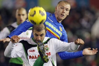 El racinguista Kennedy despeja un balón ante el defensa francés del Valencia Jeremy Mathieu