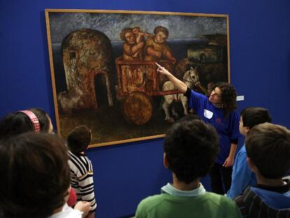 Una monitora explica un cuadro de Laxeiro a los pequeños visitantes del museo pontevedrés.