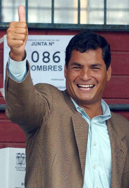 Rafael Correa saluda ante las cámaras despues de introducir su voto en las urnas.