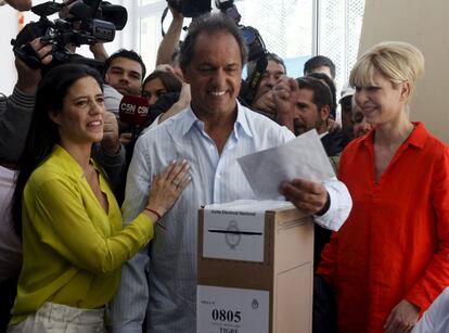 El candidato presidencial Daniel Scioli deposita su voto junto a su esposa Karina Rabolini y su hija Lorena en un colegio electoral de la localidad de Tigre, provincia de Buenos Aires.