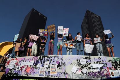 Mujeres muestran carteles de protesta en la fuente de el Caballito, sobre el Paso de la Reforma, este viernes.