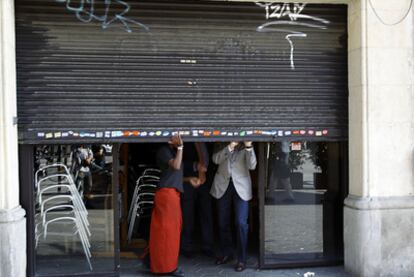 Un café del paseo de Gràcia con la persiana medio bajada.