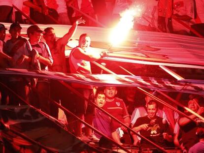 Seguidores de River Plate encienden una bengala durante un partido. 