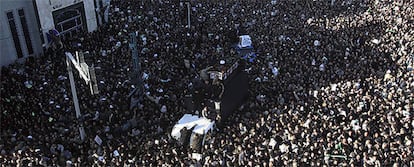 Un coche traslada entre la multitud el féretro del gran ayatolá iraní, Hosein Ali Montazerí.