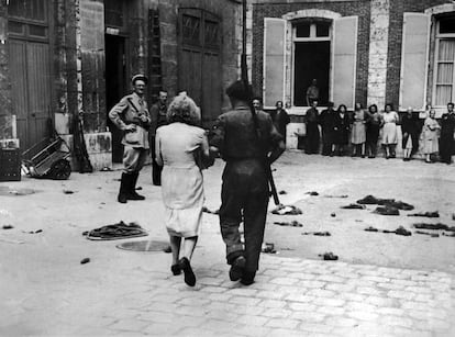 Otra de las imágenes de la serie de Robert Capa que muestra a una mujer acusada de colaboracionismo siendo acompañada al ayuntamiento de Chartres para ser rapada en 1944.
