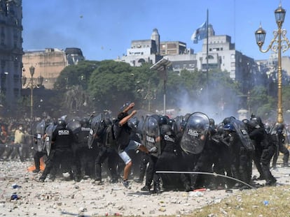 Manifestantes cercam grupo de policiais durante os distúrbios em frente ao Congresso argentino.