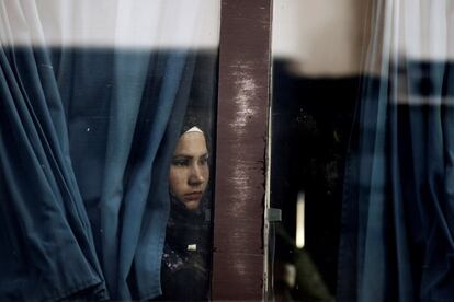 Refugiados esperan para ser trasladados tras desembarcar del ferri 'Nissos Rodos', procedente de la isla de Lesbos, en el puerto del Pireo, en Atenas (Grecia).