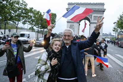 Partidarios de Emmanuel Macron celebran el triunfo sobre Le Pen en los Champs Elysees con el Arco del Triunfo al fondo.