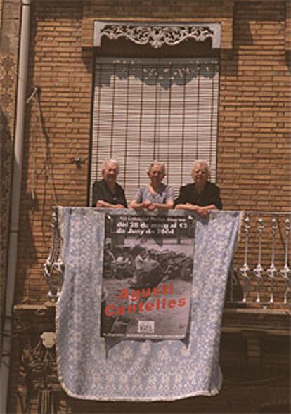 Antonieta, Pepa y Lola, de izquierda a derecha, junto al cartel de la exposición en el balcón de su casa.