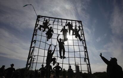 Estudiantes palestinos suben un obstáculo durante unos ejercicios militares en Rafah, al sur de la Franja de Gaza (Palestina), 9 de enero 2014.