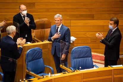 Alberto Núñez Feijóo, a la derecha, felicita a Alfonso Rueda (en el centro) en el Parlamento de Galicia, este jueves.
