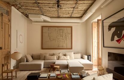 El arquitecto Jon Albistur decidió picar el pladur del falso techo hasta dejar a la vista las vigas de madera originales del edificio. Al fondo, sofá modular obra del arquitecto. Justo delante, un banco de Charlotte Perriand de los años cincuenta.