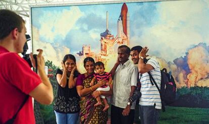 Una familia se fotografía ante una imagen del despegue de un transbordador.