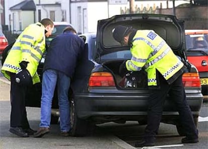 Policías británicos registran un automóvil en un control cerca del aeropuerto de Heathrow.