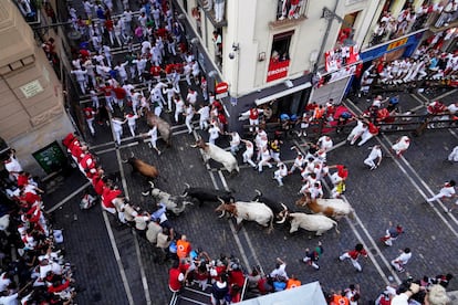 Decenas de corredores en la curva de Mercaderes con Estafeta, durante el segundo encierro de San Fermín. 