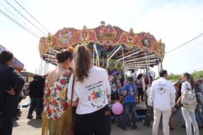 Dos chicas en la Feria, una de ellas con el lema inclusivo.