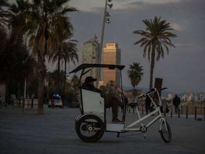Un home assegut en un bicitaxi, a Barcelona, sense clients.