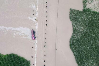 In this aerial photo released by Xinhua News Agency, a truck turned on its side is seen as flood waters flowing across roads and fields in Kaiyuan Town of Shulan in northeastern China's Jilin Province on Friday, Aug. 4, 2023