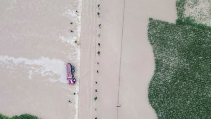 In this aerial photo released by Xinhua News Agency, a truck turned on its side is seen as flood waters flowing across roads and fields in Kaiyuan Town of Shulan in northeastern China's Jilin Province on Friday, Aug. 4, 2023.