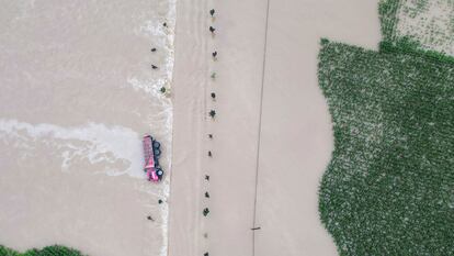 In this aerial photo released by Xinhua News Agency, a truck turned on its side is seen as flood waters flowing across roads and fields in Kaiyuan Town of Shulan in northeastern China's Jilin Province on Friday, Aug. 4, 2023.