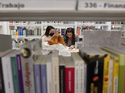 Tres jóvenes estudian en la biblioteca pública municipal del barrio de San Fermín, en Madrid, recientemente inaugurada.