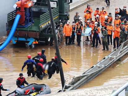 Miembros de los equipos de rescate trasladan el cuerpo de una víctima mortal de la inundación de un túnel en Cheongju, el 16 de julio.