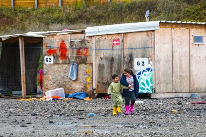 Dos niños pasean por un campo de migrantes, en Grande-Synthe (Francia).
