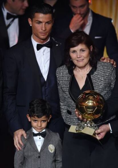 El jugador con su madre y su hijo con el último balón de oro, conseguido el año pasado.