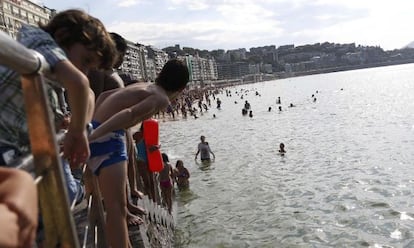 Vista de la playa de la Concha de San Sebastián llena de gente coincidiendo con el horario de la pleamar.