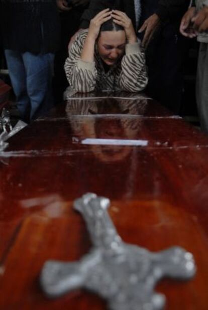 A relative of a farmer killed in police clashes mourns over his coffin.