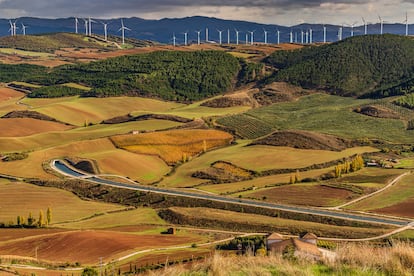 Canal de Navarra flanqueado en Añorbe con turbinas eólicas en la montaña.