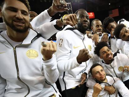 Los jugadores de los Warriors muestran los anillos de campeones de la NBA.