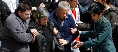 Los padres de Cristina Martín son ayudados por su hijo mayor y una agente de la Guardia Civil tras el funeral.