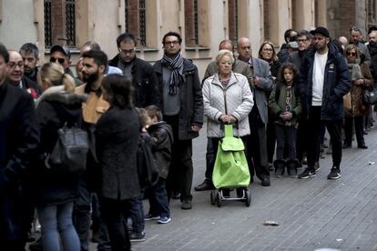 People wait in line outside the Polytechnic University of Catalonia to vote in the Catalan regional elections.