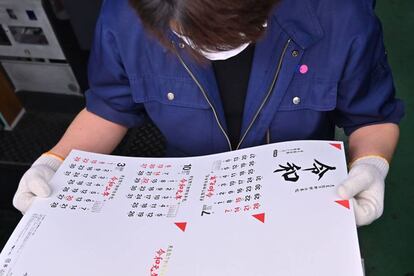 Un trabajador de una imprenta revisa un calendario con el nombre de la nueva era imperial, Reiwa.