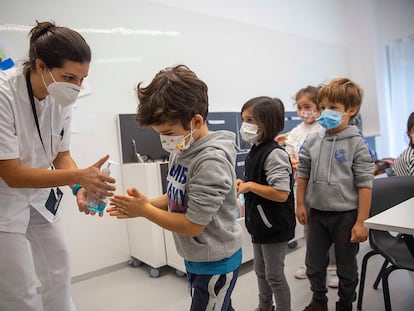 La enfermera del colegio Aldapeta María, en San Sebastián, ofrece gel hidroalcohólico a alumnos del centro antes de comenzar la clase.