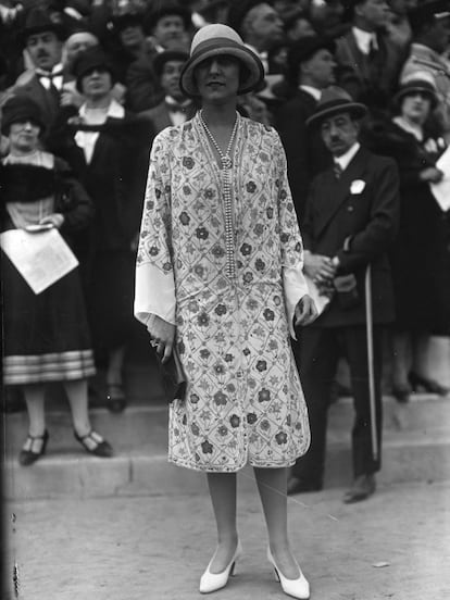 Vestido de estampado floreado acompaña por el complemento estrella de la época: el collar de perlas.